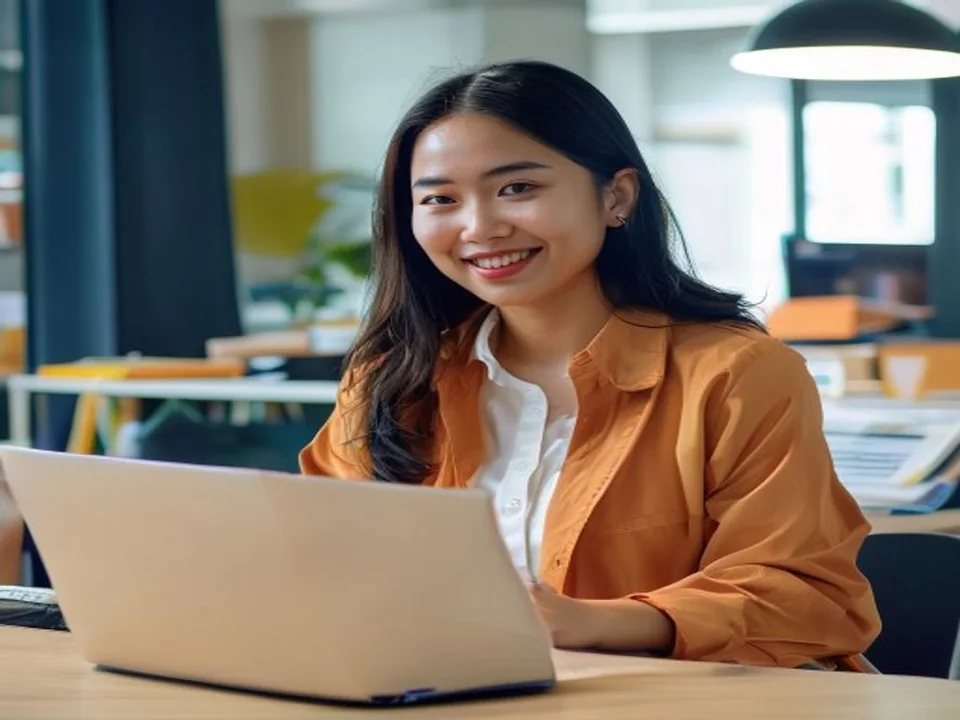 An e-commerce professional checks a parcel beside her laptop.